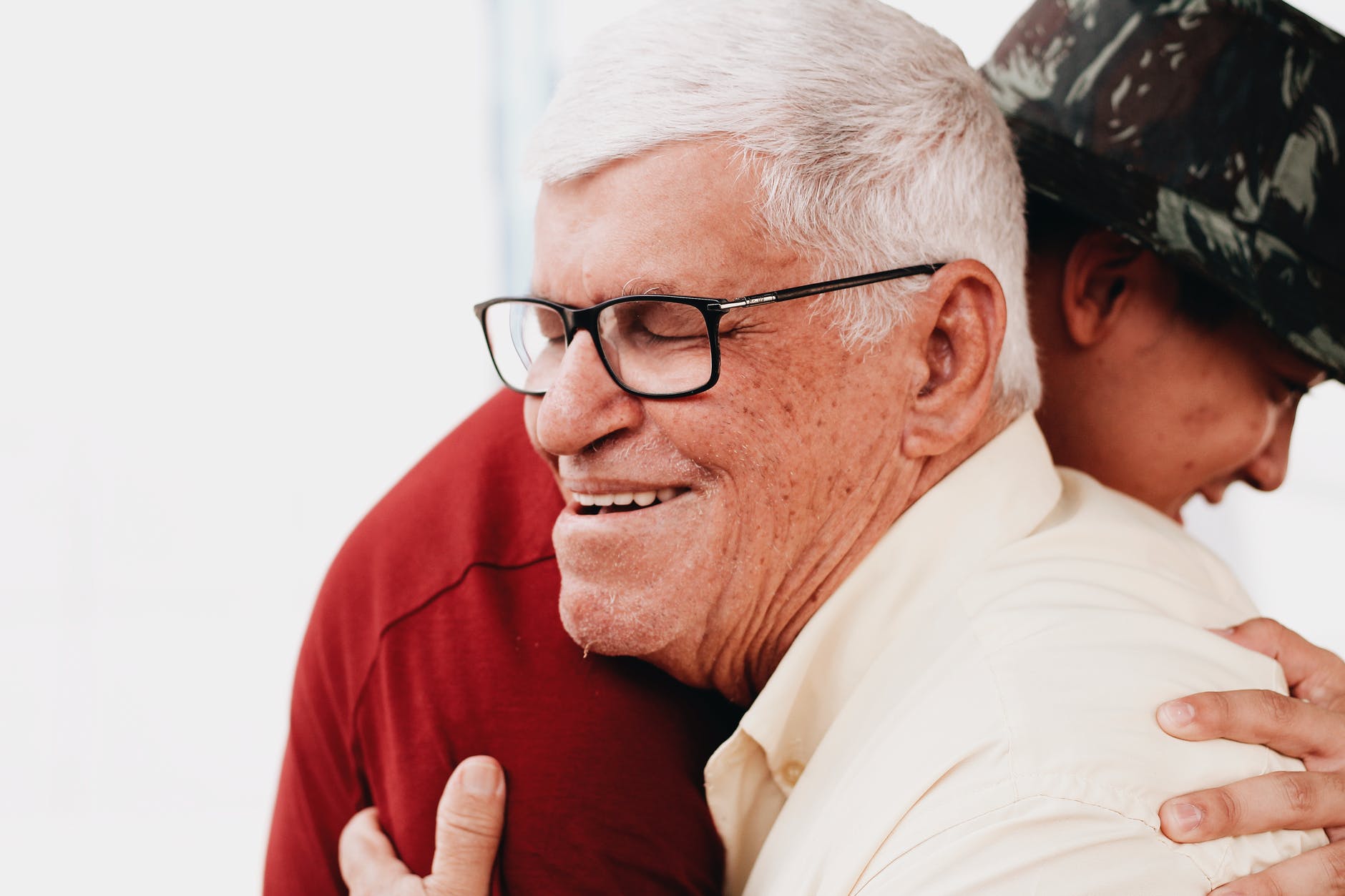 senior man hugging grandson and smiling
