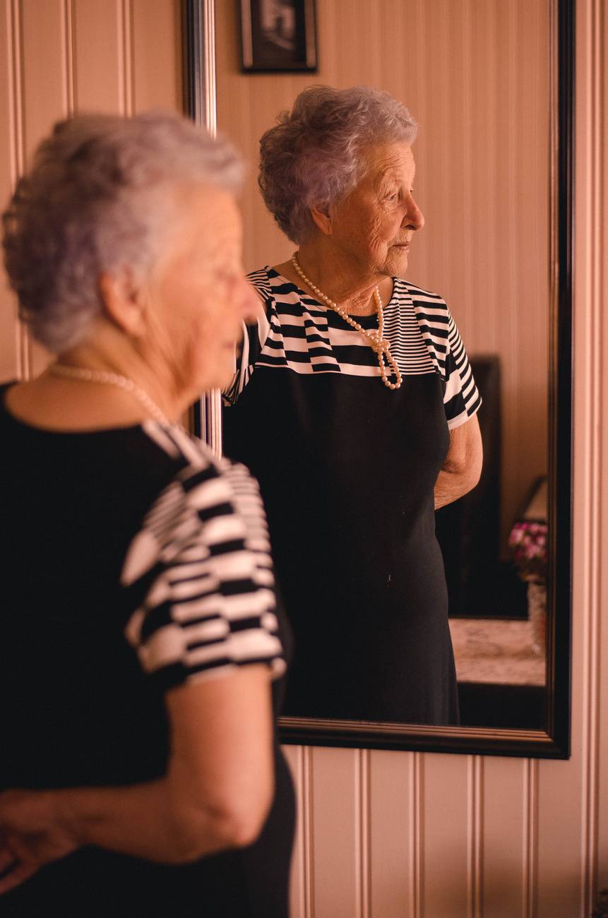photo of woman standing in front of mirror