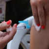 Uma pessoa com uma seringa na mão faz aplicação de vacina numa outra pessoa. Foto: José Cruz/Agência Brasil